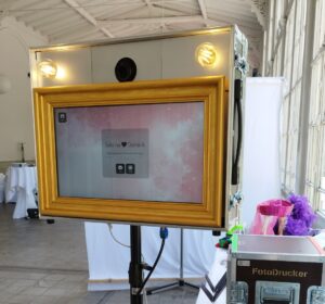 FotoBox auf Stativ mit FotoDrucker im Hintergrund